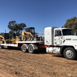 Upt Drop Deck Loaded With Cat Equipment Pulled By A Mack Truck