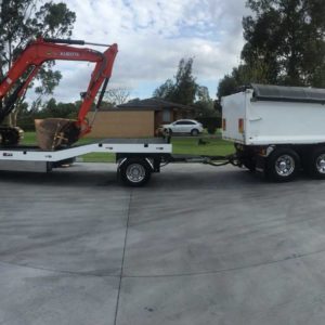 3 Axle Dog Towed By A Kenworth With A Kubota Excavator